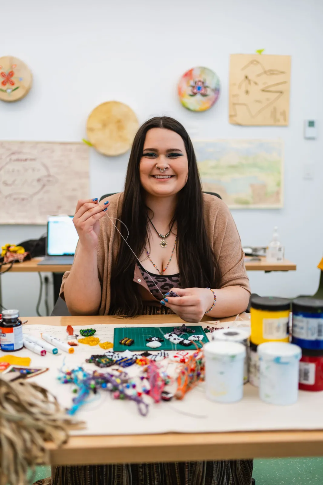 Danielle Piper beading at her worktable in the studio
